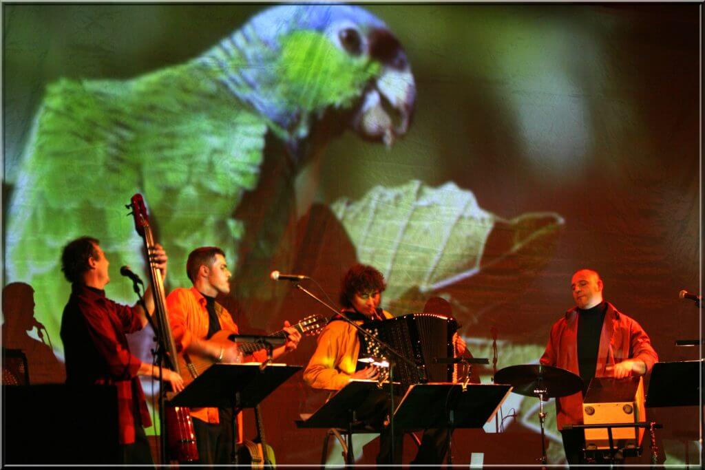 des musiciens devant une projection d'animaux argentins