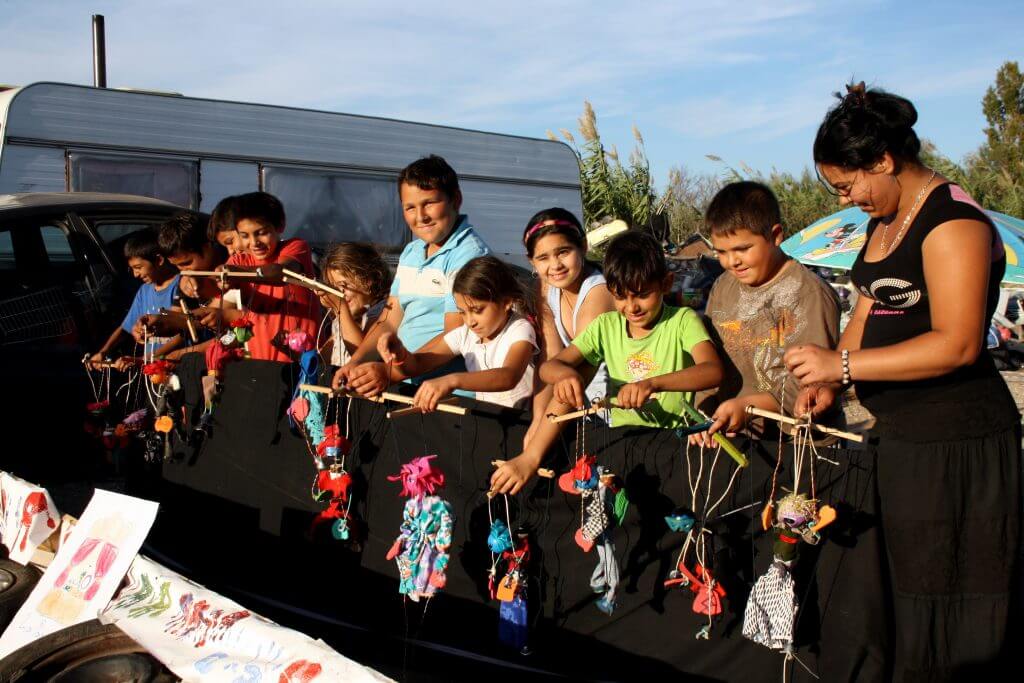 des enfants roms tenant des marionnettes