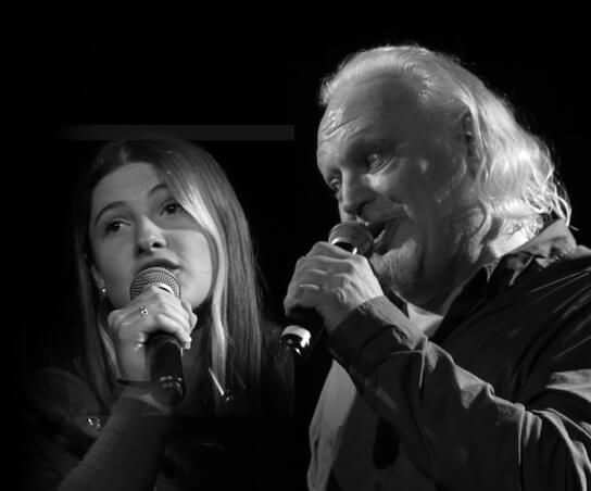 Un homme et une jeune femme chantant côte à côte